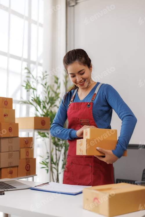 Preview: Asian seller preparing shipping packages for online orders