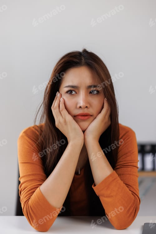 Preview: Young woman feeling worried, stressed, or bored at work