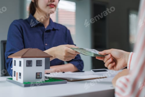 Preview: Hands exchanging money for real estate payment