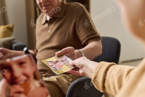 Preview: Senior Couple Holding Family Photos during Memory Care Session