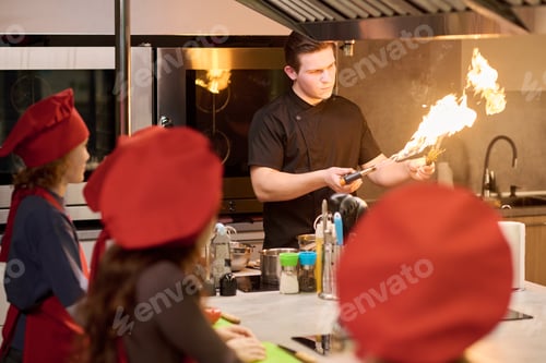 Preview: Adult Man Demonstrating Flambe Cooking during Culinary Class