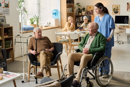 Preview: Senior Men Receiving Care Support in Nursing Home Common Area