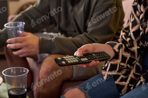 Preview: Teenager Holding Remote While Watching Tv at Home with Friend