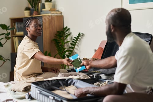 Preview: Black Adult Couple Packing Luggage and Sharing Travel Documents