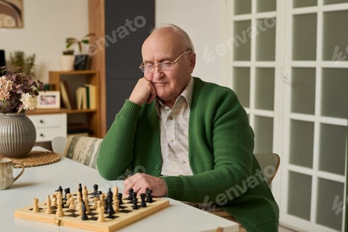 Preview: Senior Man Playing Chess at Home for Active Aging Lifestyle