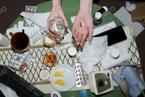 Preview: Adult Woman Holding Pills and Water during Home Cold Treatment