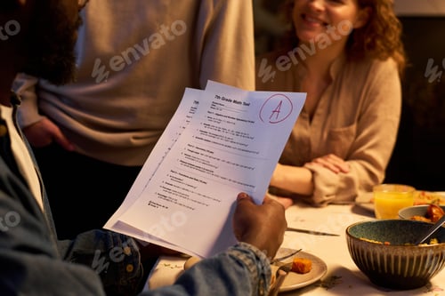 Preview: Black Teenager Showing Grade Math Test to Parents at Dinner
