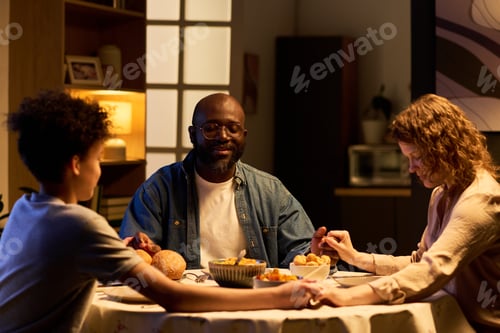 Preview: Black Family Praying before Dinner at Home for Faith-based Living
