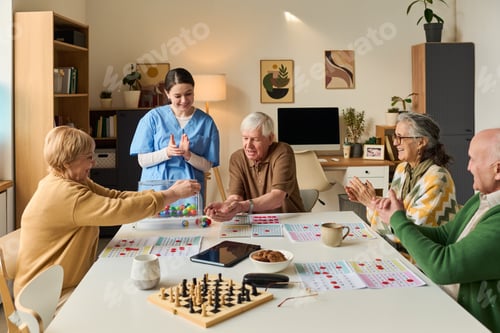 Preview: Senior Group Playing Bingo with Nurse during Care Home Activity