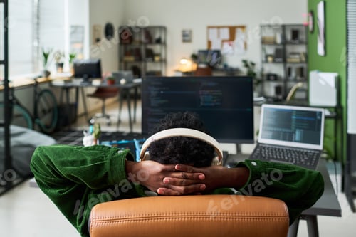 Preview: Black Man Leaning Back at Coding Desk during Remote Work Break