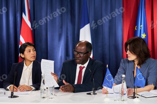 Preview: Diverse Diplomats Reviewing Agreement during International Summit