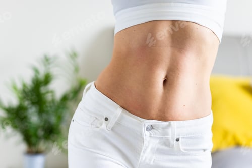 Preview: Close-up of woman's toned abdomen in white clothing indoors