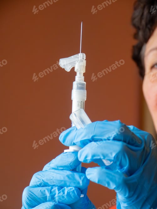 Preview: Healthcare professional in blue gloves preparing a prefilled Sandostatin LAR syringe with needle for