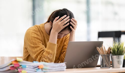 Preview: Stressed Asian Woman with Head in Hands Working at Messy Office Desk
