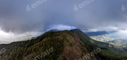 Preview: Dramatic Mountain Ridge and Forest Under Heavy Clouds Over a Valley in British Columbia, Canada