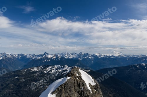 Preview: Snow-Capped Mountain Ridge Overlooking Alpine Range and Valleys Under Blue Sky in BC, Canada