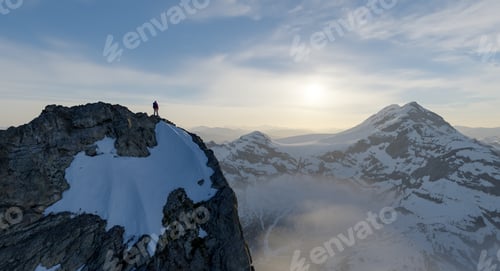 Preview: Mountaineer Standing On Snowy Peak At Sunrise Over Vast Alpine Mountain Landscape