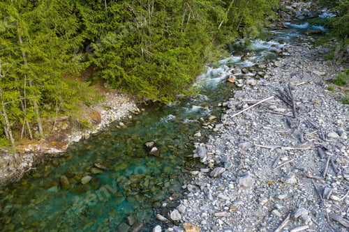 Preview: Aerial View of Rocky Riverbank and Evergreen Forest With Clear Water Near Harrison Lake, BC, Canada