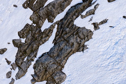 Preview: Aerial View of Snow-Covered Rocky Alpine Mountain in BC, Canada With Rugged Texture