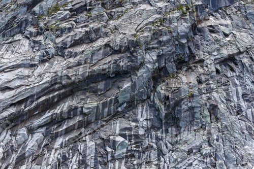Preview: Textured Rock Cliff Face With Vertical Striations and Moss on Mountain Slope in British Columbia, Ca