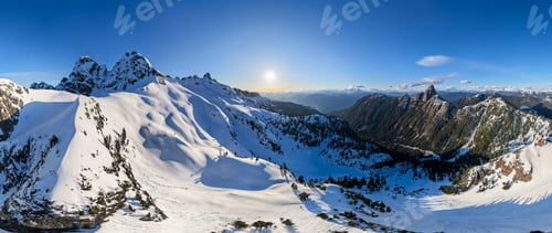 Preview: Panoramic Snow-Covered Mountain Range With Sun Over BC, Canada Coastal Mountains At Sunset