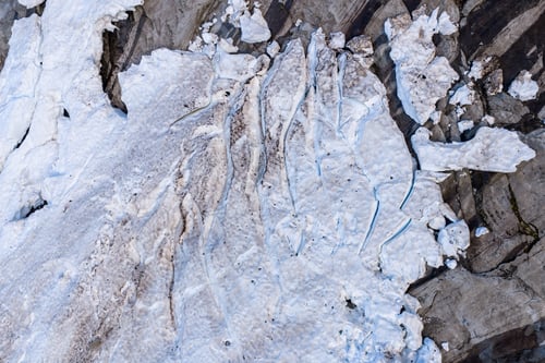 Preview: Aerial View of Glacier Ice and Snow With Crevasses on Rocky Coast in BC, Canada