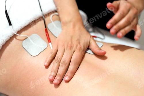 Preview: Hands administering electrical muscle stimulation on a bare lower back