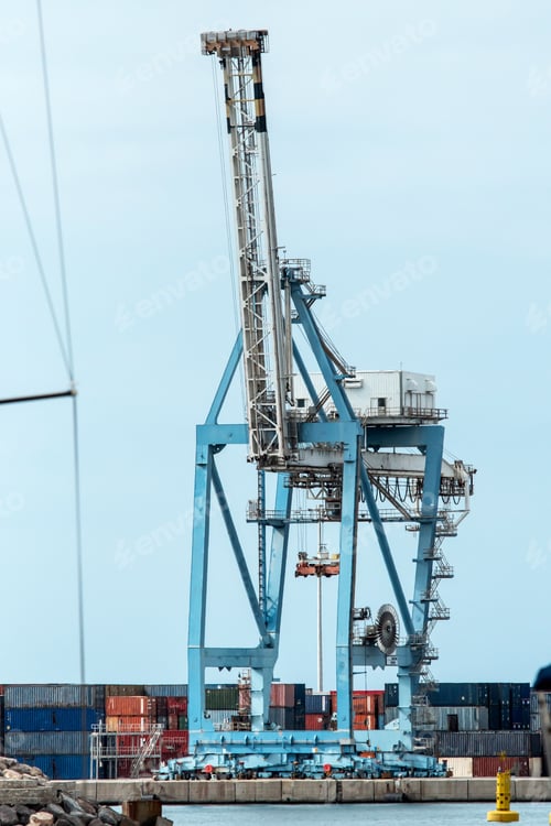 Preview: A big blue crane on the dock with a man inside.