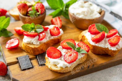 Preview: Bruschetta with ricotta and strawberry on a stone tabletop. Berries toast summer breakfast, healthy