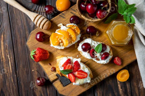 Vista previa: Assorted bruschetta with ricotta, honey, cherries, apricot and strawberry on a rustic table. Berries