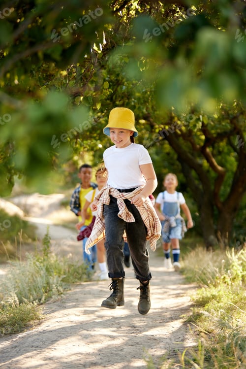Preview: Happy, cheerful kids in casual comfortable clothes going hiking, walking in park together on warm su