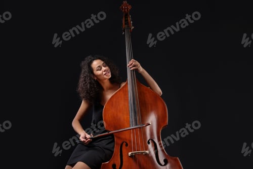 Preview: Woman playing double bass on black background