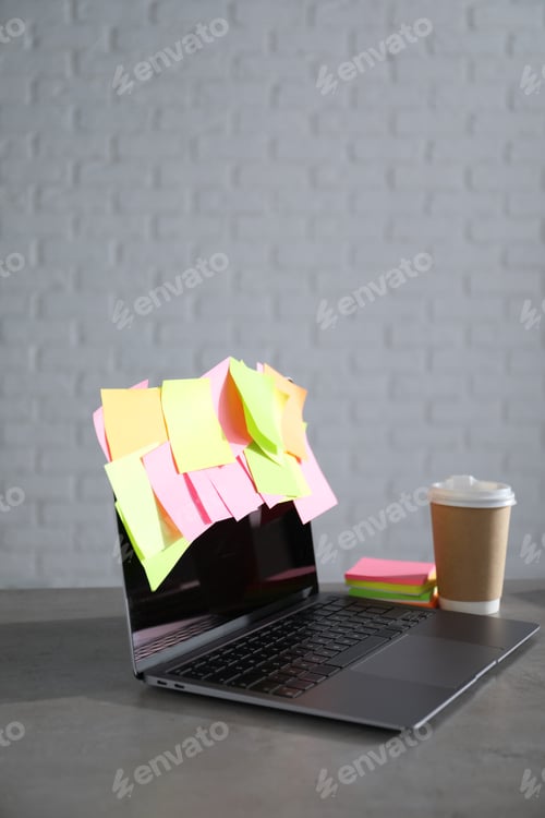 Preview: Laptop with colorful sticky notes and cup of coffee on gray table indoors, space for text. Multitask