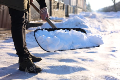 Preview: Man removing snow with shovel outdoors, closeup