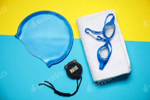 Preview: Swim cap, towel, goggles and digital stopwatch on color background, flat lay. Swimming accessories