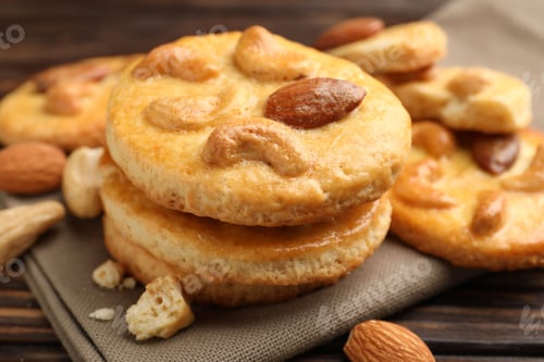Preview: Delicious cookies with nuts on wooden table, closeup