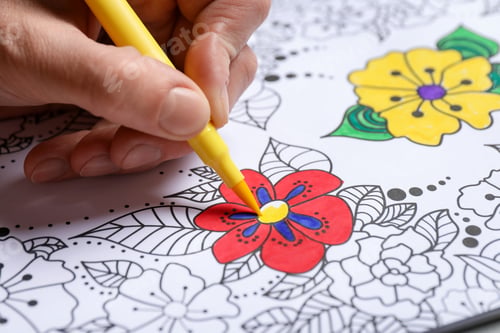 Preview: Woman coloring antistress picture with felt tip pen at table, closeup