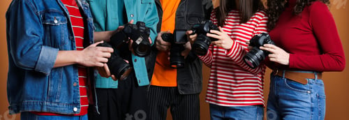 Preview: Group of photographers with professional cameras against brown background