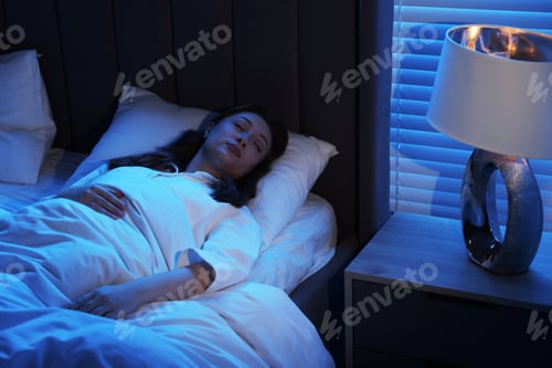 Preview: Woman sleeping with illuminated night lamp at home