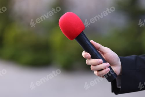 Preview: Professional journalist with microphone outdoors, closeup. Space for text