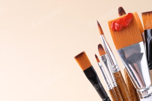 Preview: Different paintbrushes on beige background, closeup. Space for text