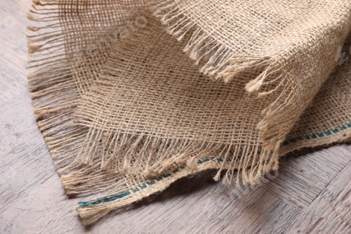 Preview: Natural burlap fabric on wooden table, closeup