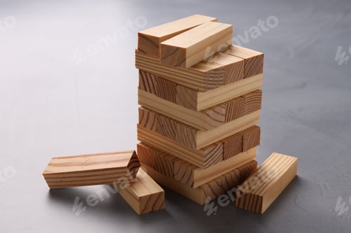 Preview: Stack of wooden blocks on grey table, closeup. Growth and strategy