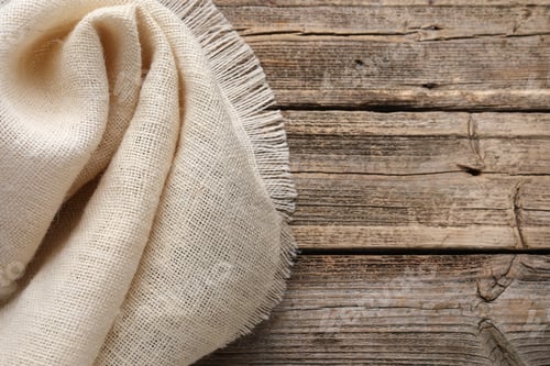 Preview: Natural burlap fabric on wooden table, top view. Space for text
