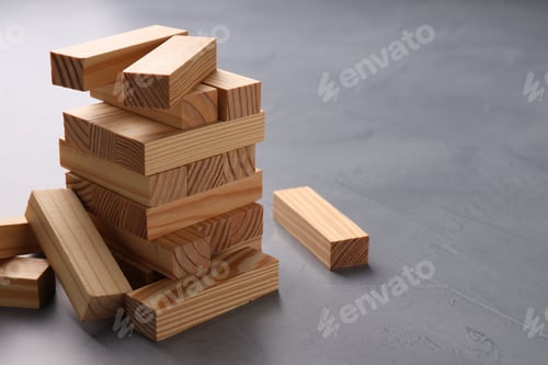 Preview: Growth and strategy. Stack of wooden blocks on grey table, closeup. Space for text