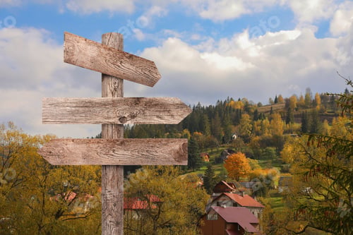 Preview: Wooden signpost with arrows pointing in different directions in mountains