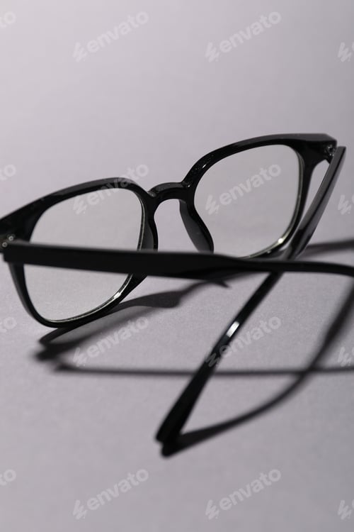 Preview: Pair of eyeglasses on grey background, closeup