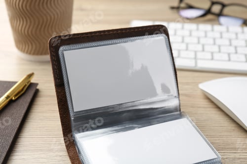 Preview: Leather business card holder with blank cards on wooden table, closeup