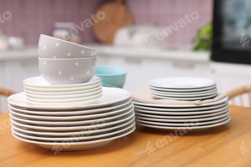 Preview: Set of clean dishes on wooden table in kitchen, closeup