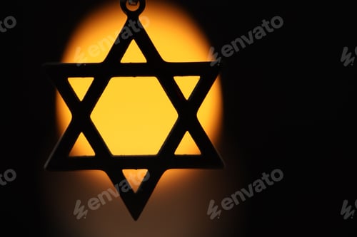 Preview: Holocaust Remembrance Day. Pendant in shape of Star of David against black background with blurred l